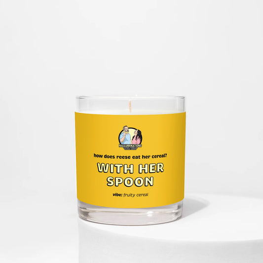 With Her Spoon – fruity cereal scented funny coconut soy candle in 8oz clear glass jar with yellow label, photographed on white background.