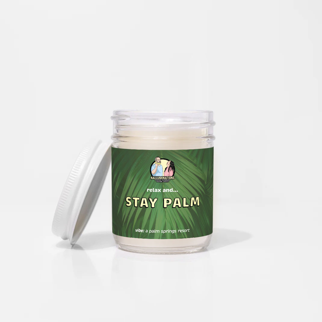 Stay Palm – resort-inspired funny coconut soy candle with green tea and rose petals in 6.5oz clear glass jar with white lid and green palm label, photographed on white background.