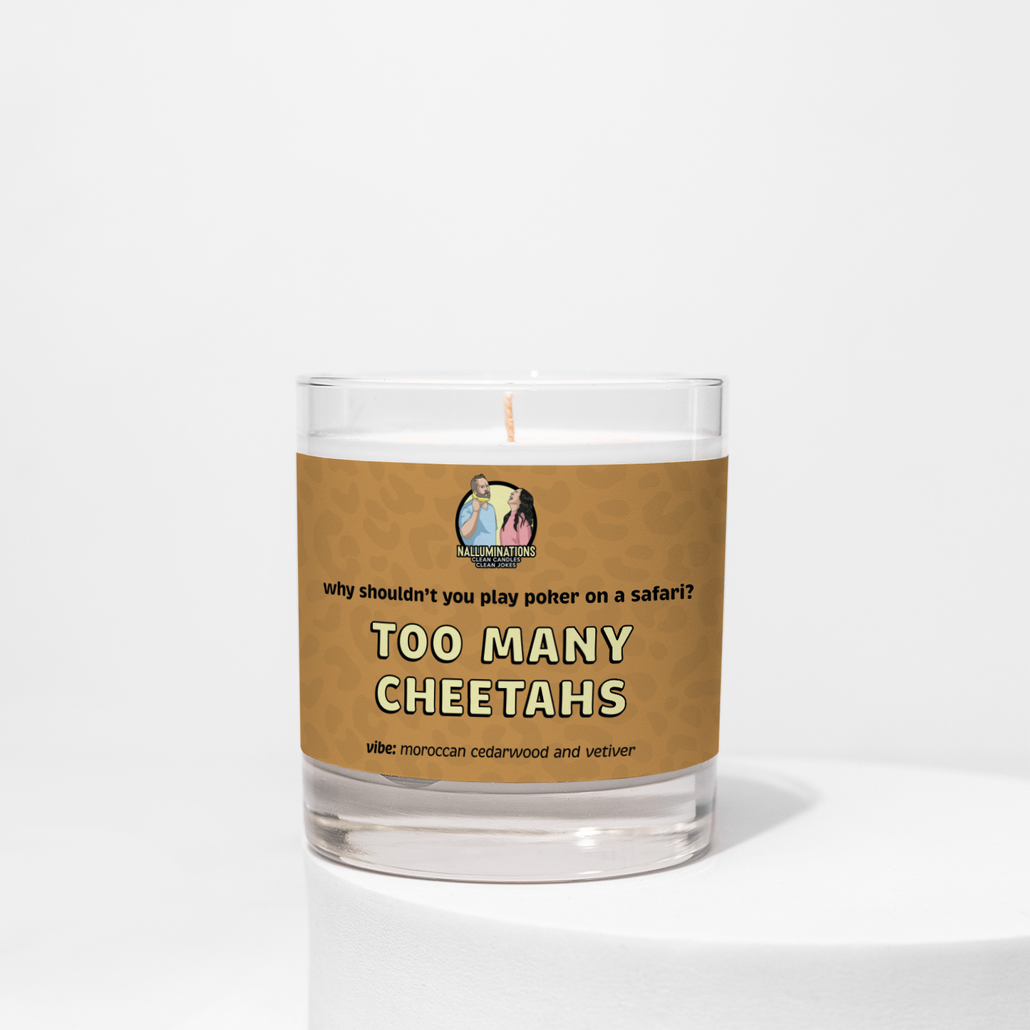 8oz coconut soy candle in a clear glass jar with a cheetah-print brown label that reads “Why shouldn’t you play poker on a safari? Too Many Cheetahs.” Moroccan cedarwood and vetiver scent, displayed on a white background.