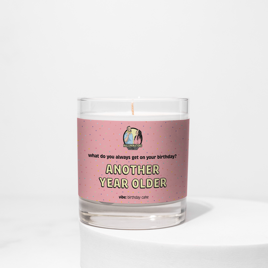 Coconut soy 8oz candle labeled “Another Year Older” with a pink confetti design and birthday cake scent, unlit on a white background.