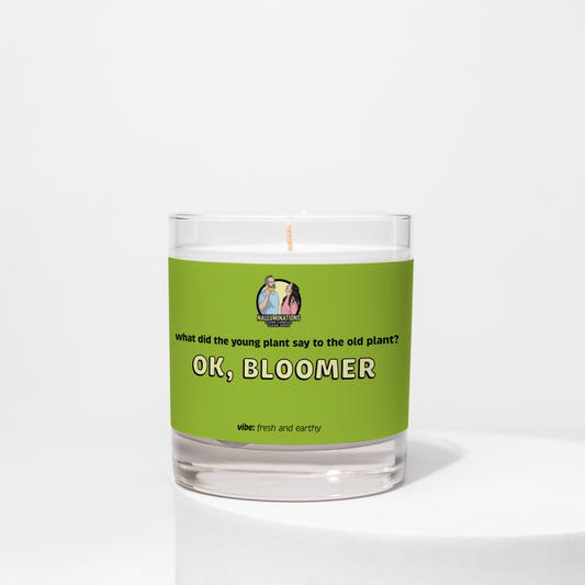 Ok, Bloomer – fresh earthy funny coconut soy candle with gardenia, sandalwood, and moss in 8oz clear glass jar with green label, photographed on white background.