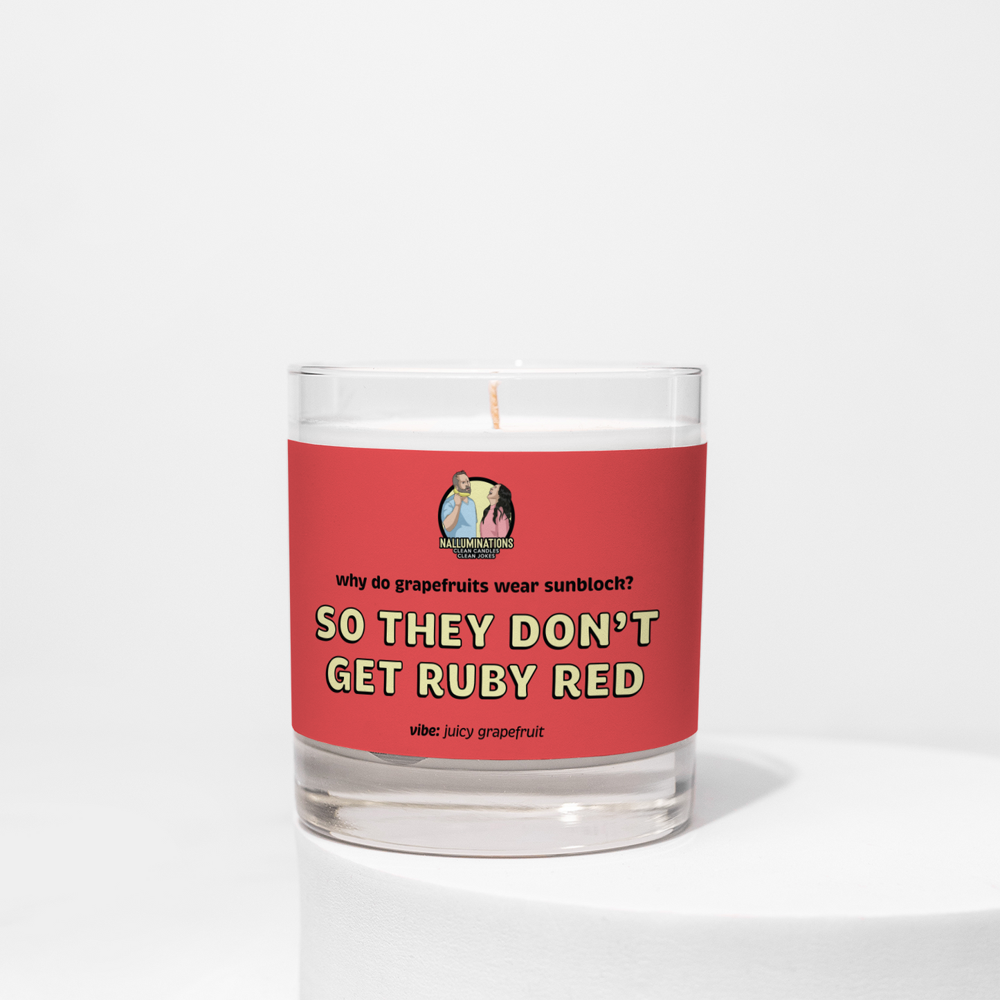 So They Don’t Get Ruby Red – juicy grapefruit funny coconut soy candle in 8oz clear glass jar with red label, photographed on white background.