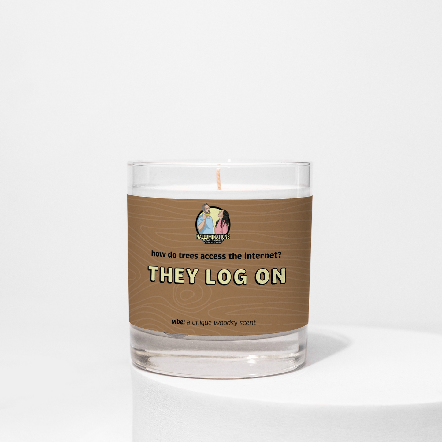 8oz coconut soy candle in a clear glass jar with a brown woodgrain label that reads “How do trees access the internet? They log on.” Unique woodsy scent, displayed on a white background.