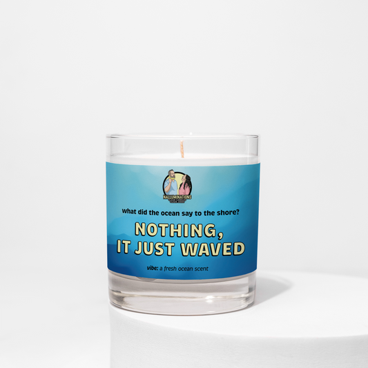 8oz coconut soy candle in a clear glass jar with a blue label that says “Nothing, It Just Waved.” Fresh ocean-scented candle shown on a white background.