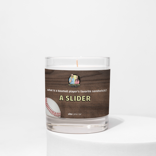 8oz coconut soy candle in a clear glass jar with a wood-grain label that reads “What is a baseball player’s favorite sandwich? A Slider.” The label features a baseball graphic, with the scent vibe listed as pine tar. The candle is unlit and placed against a white background.