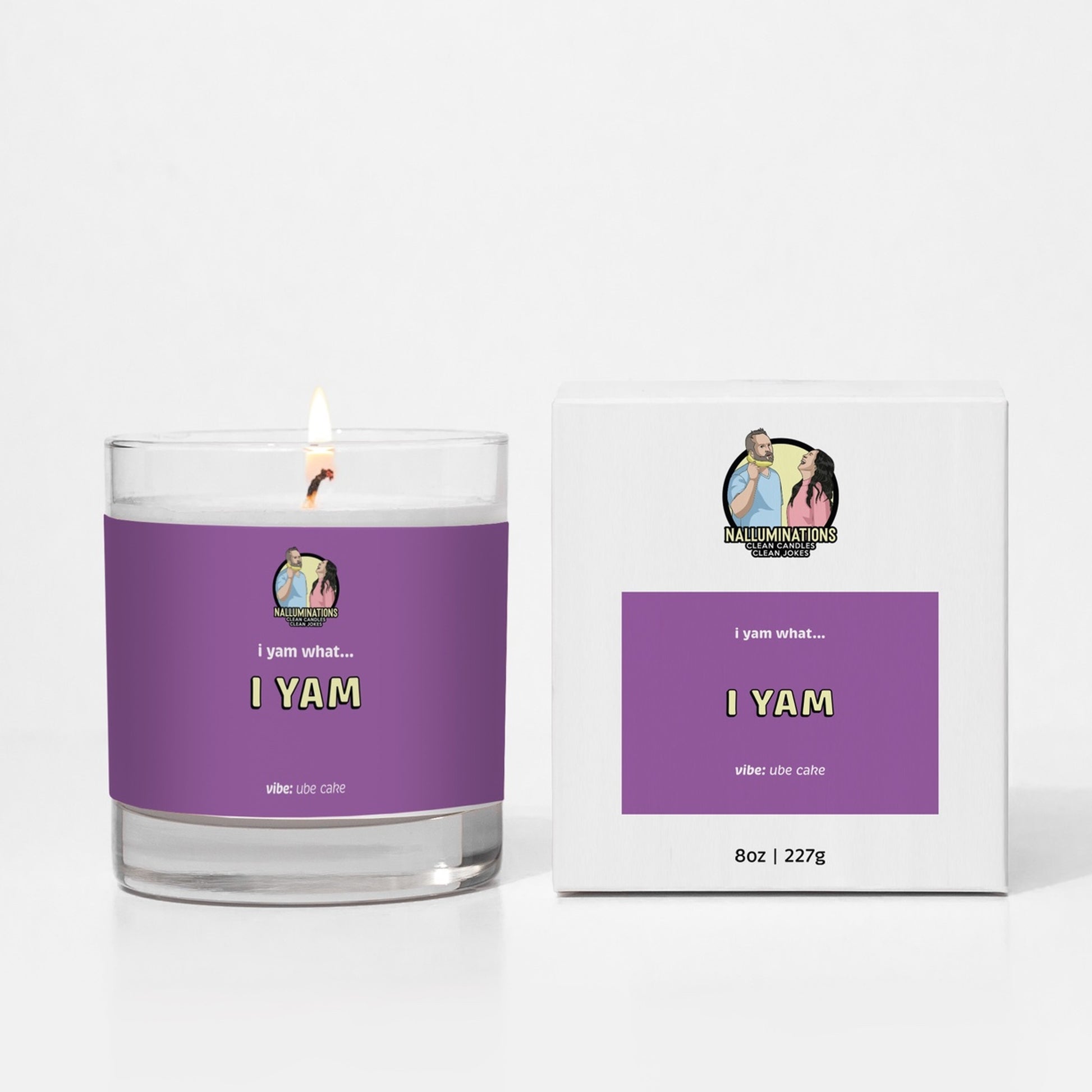 Coconut soy 8oz candle labeled “I Yam” in a bold purple design with ube cake scent, shown lit next to its matching box on a white background.
