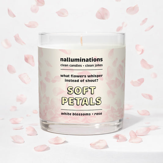 Nalluminations 8oz coconut soy candle in clear glass vessel with text "soft petals" on a light background with pink flower petals.